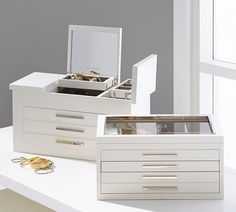 two white jewelry boxes sitting on top of a table