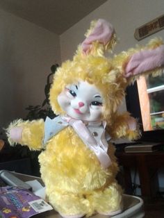 a yellow stuffed rabbit sitting on top of a table