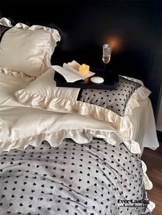 a black and white polka dot bed spread with candles on the end table next to it