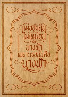 an engraved wooden plaque with the words, in english and thai writing on it's edges