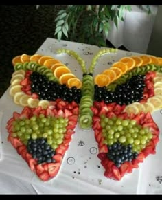 a butterfly made out of fruit sitting on top of a table