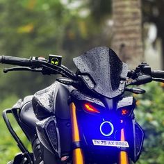 a close up of a motorcycle parked on the side of a road with trees in the background