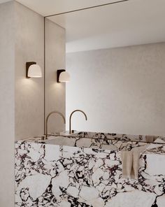 a bathroom with marble counter tops and lights