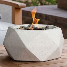 a concrete fire pit sitting on top of a wooden table