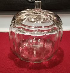 a clear glass jar sitting on top of a red table cloth