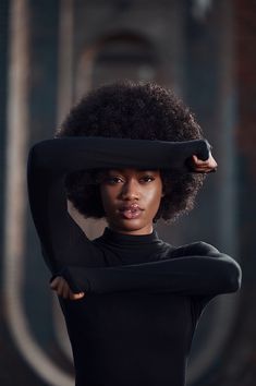 a woman with an afro is posing for the camera