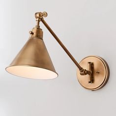 an antique brass swing arm wall light