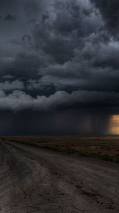 storm clouds loom over an empty dirt road