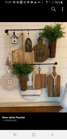 the wall is decorated with wooden cutting boards and potted plants on hooks that are hanging from them