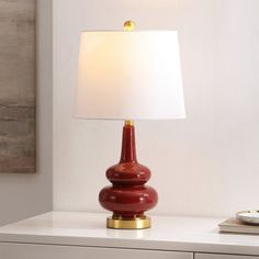 a red lamp sitting on top of a white table