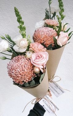 two bouquets of flowers are wrapped in brown paper