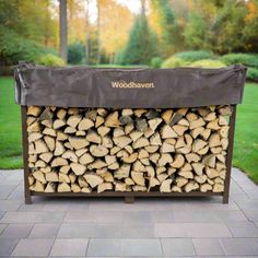 a large pile of logs sitting on top of a brick walkway next to a lush green park