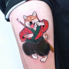 a man with a tattoo on his leg has a cat holding a baseball bat and ball