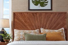 a bed with wooden head board and pillows