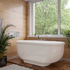 a large white bathtub sitting in front of a window next to a potted plant