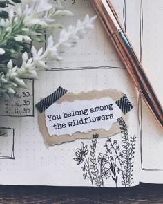 a notepad with the words you belong among the wildflowers on it