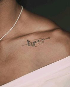 a woman's chest with a butterfly tattoo on the left side of her chest