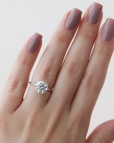 a woman's hand with a ring on it and a diamond in the middle