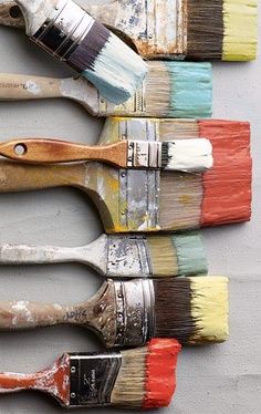 five paint brushes lined up in a row on top of each other, with different colors