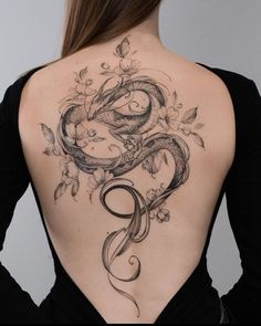 the back of a woman's body with tattoos on it