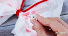 a person is holding a ring in their left hand and tied with a red string