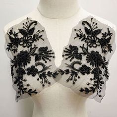 a white and black top on a mannequin's torso, with embroidered flowers