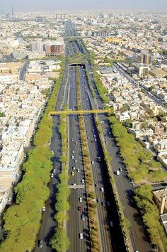 an aerial view of a city with lots of traffic on the street and in the middle of the road