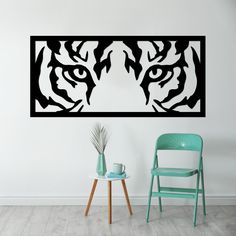 a chair and table in front of a wall with an image of a tiger's head