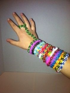 a person's hand with multicolored bracelets on their wrist and arm