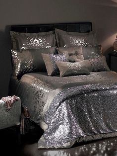 a bed with silver sequins and pillows on it