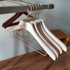 clothes hangers are hanging on a rack in a room with hardwood floors and walls