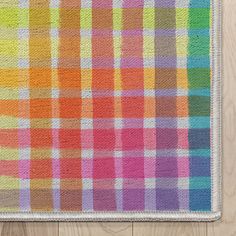 a multicolored plaid rug on a wooden floor