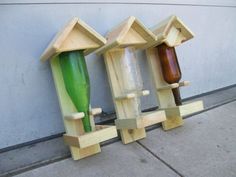 three wooden birdhouses sitting next to each other on the side of a building,