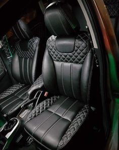 the interior of a car with black leather seats and green trimmings on it