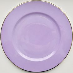 a purple plate with gold trim on the edge is shown in front of a white background