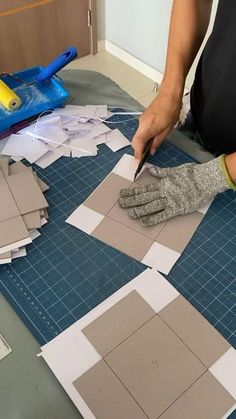 a person cutting out paper on top of a table