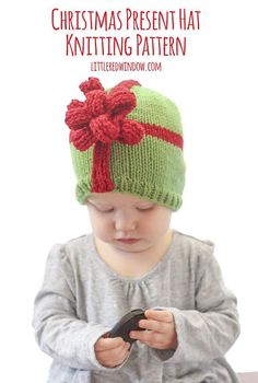 a baby wearing a knitted christmas present hat