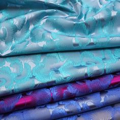 several different colored fabrics are stacked on top of each other, one in blue and the other in pink