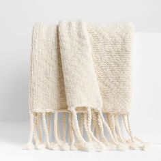 two white towels folded on top of each other with tasselled ends and fringes