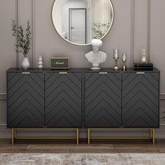 a black and gold sideboard with a round mirror on it's wall above it