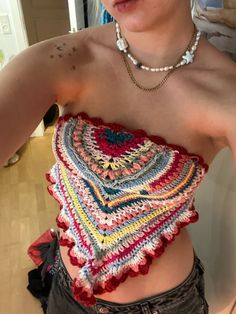 a close up of a person wearing a top with crocheted designs on it