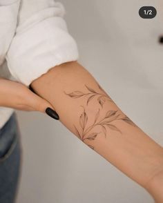 a woman's arm with a flower tattoo on the left side of her arm