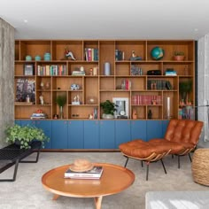 a living room filled with furniture and bookshelves next to a wall full of shelves