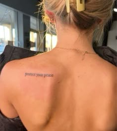 a woman with a tattoo on her back saying protect your peace