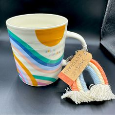 a coffee mug with a tasseled keychain attached to it and a tag that says made in the usa