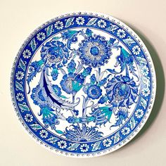 a blue and white plate sitting on top of a wall