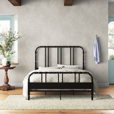 a bed sitting in a bedroom on top of a wooden floor next to a window