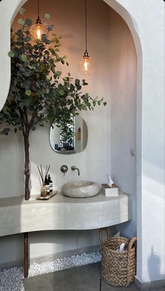 a bathroom with a tree in the corner and a sink on the counter next to it