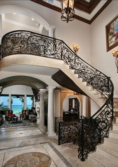 an elegant staircase with wrought iron railings leads up to the second floor, which is decorated in white and black