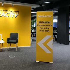 a yellow sign that is in front of a chair and table with chairs around it